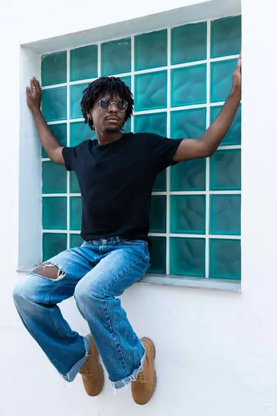 Afro Chłopiec Okularach Przeciwsłonecznych Siedzi Oknie Zdjęcie Pionowe — Zdjęcie stockowe
