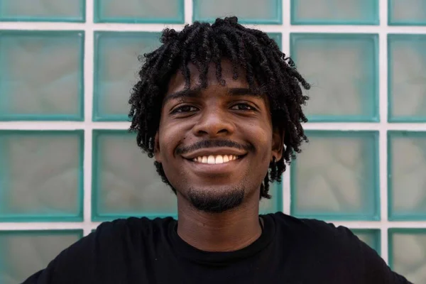 Kıvırcık saçlı, gülümseyen afro çocuk. Turkuaz arkaplan