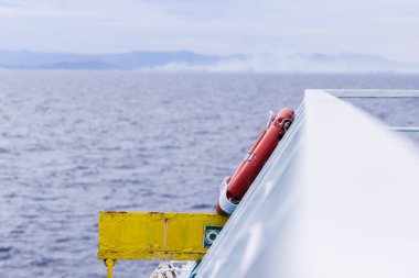 Bir geminin korkuluklarına yerleştirilmiş bir can yeleği fotoğrafı. Boşluğu sol tarafa kopyala.