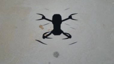  Uçan İHA 'nın gölgesi. Quadcopter gölgesi asfalt zeminde alçaktan uçuyor. Yerdeki video drone gölgesini yükleyin. Uçan bir dronun silueti. Quadcopter Shaing yarış olacak. Yüksek kalite 4k görüntü