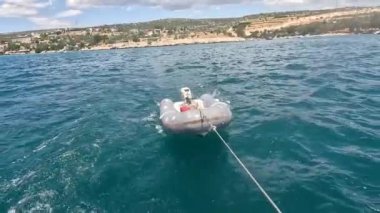  Lastik şişme bot, Türkiye Körfezi 'nde yelken açarken bir yatın arkasında sürüklendi.
