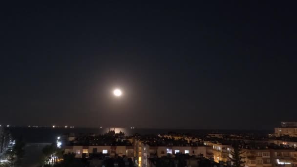 海に満ちた満月が 海に浮かぶ街の雲の上に タイムラプス 高品質の4K映像 — ストック動画