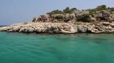 Türkiye 'nin Alanya kıyı şeridi boyunca dalgalarda pürüzsüz bir hareket. 4k video 18 saniye. Türk Rivierası 'nda Akdeniz gezisi. Güzel deniz manzarası. Yüksek kalite 4k görüntü