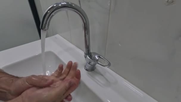 Ein Wasserstrahl Aus Einem Wasserhahn Ergießt Sich Ein Weißes Waschbecken — Stockvideo