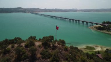 Katalan Gölü üzerindeki köprü ve Türk bayrağı rüzgarda dalgalanıyor. Adana. Hindi.Yüksek kalite 4K görüntü