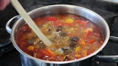 A very tasty beef lentil soup is being cooked on the stove, the cook is cooking the soup. Mixing. Slowmotion. High quality 4k footage