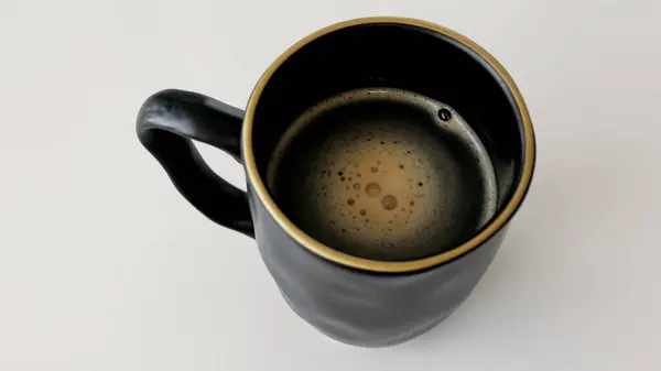 Siyah arka planda yükselen buharlı bir video fincan sıcak kahve. Yüksek kalite 4k görüntü