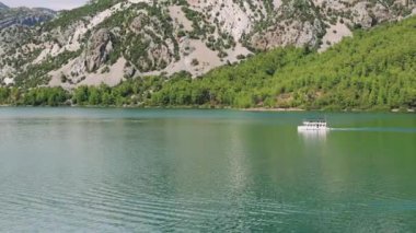 Hava manzarası: Dağlar ve ormanlarla çevrili temiz turkuaz sularla birlikte Türkiye 'deki Yeşil Kanyon' da turistlerin yelken açtığı turistik bir tekne. Yüksek kalite 4k görüntü