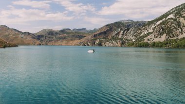 Hava manzarası: Dağlar ve ormanlarla çevrili temiz turkuaz sularla birlikte Türkiye 'deki Yeşil Kanyon' da turistlerin yelken açtığı turistik bir tekne. Yüksek kalite 4k 