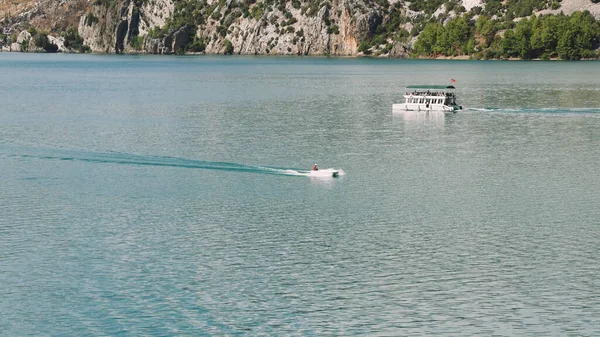 Hava manzarası: Dağlar ve ormanlarla çevrili temiz turkuaz sularla birlikte Türkiye 'deki Yeşil Kanyon' da turistlerin yelken açtığı turistik bir tekne. Yüksek kalite 4k 