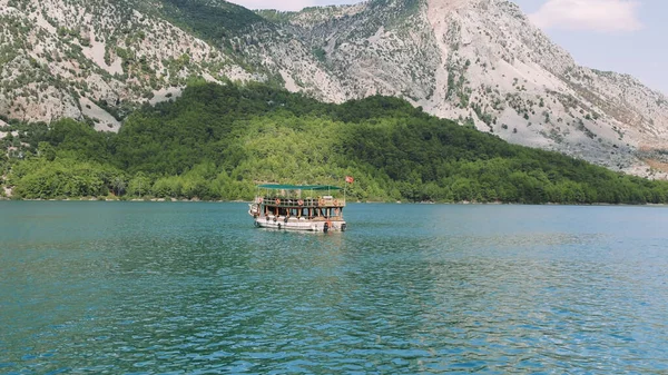 Hava manzarası: Dağlar ve ormanlarla çevrili temiz turkuaz sularla birlikte Türkiye 'deki Yeşil Kanyon' da turistlerin yelken açtığı turistik bir tekne. Yüksek kalite 4k 