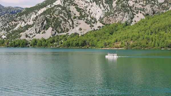 Hava manzarası: Dağlar ve ormanlarla çevrili temiz turkuaz sularla birlikte Türkiye 'deki Yeşil Kanyon' da turistlerin yelken açtığı turistik bir tekne. Yüksek kalite 4k 