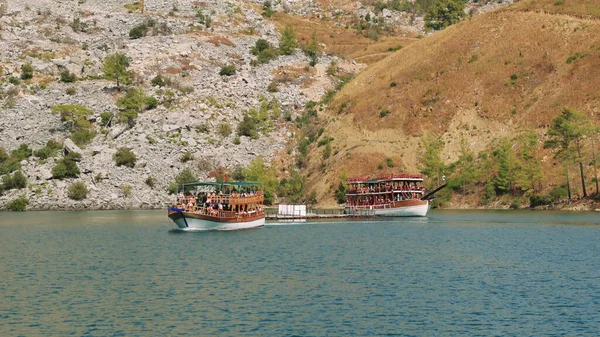 Hava manzarası: Dağlar ve ormanlarla çevrili temiz turkuaz sularla birlikte Türkiye 'deki Yeşil Kanyon' da turistlerin yelken açtığı turistik bir tekne. Yüksek kalite 4k 