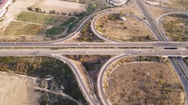 Gün batımında çok katlı otoyolda giden arabaların üst görüntüsü. Mersin. Hindi. Otoyol üst geçidi, arabalar, kamyonlar ve otobüslerle kavşak. Yüksek kalite 4k görüntü