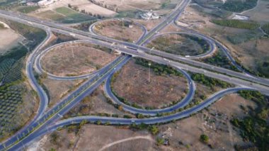 Gün batımında çok katlı otoyolda giden arabaların üst görüntüsü. Mersin. Hindi. Otoyol üst geçidi, arabalar, kamyonlar ve otobüslerle kavşak. Yüksek kalite 4k görüntü
