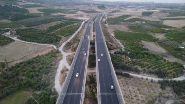 4K Hava Aracı Mersin Viyadük 'ünde otomobil trafiği. Dağların 4K 'sındaki hava manzarası ve arabalarla karayolu. Mersin. Hindi. Yolculuk, yol dönüşleri, günbatımı. Yüksek kaliteli görüntüler