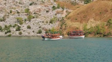 Hava manzarası: Dağlar ve ormanlarla çevrili temiz turkuaz sularla birlikte Türkiye 'deki Yeşil Kanyon' da turistlerin yelken açtığı turistik bir tekne. Yüksek kalite 4k görüntü