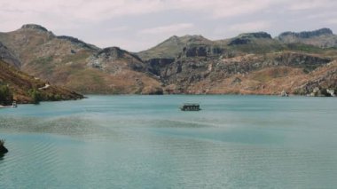 Hava manzarası: Dağlar ve ormanlarla çevrili temiz turkuaz sularla birlikte Türkiye 'deki Yeşil Kanyon' da turistlerin yelken açtığı turistik bir tekne. Yüksek kalite 4k görüntü