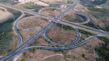 Gün batımında çok katlı otoyolda giden arabaların üst görüntüsü. Mersin. Hindi. Otoyol üst geçidi, arabalar, kamyonlar ve otobüslerle kavşak. Yüksek kalite 4k görüntü