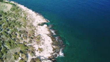 Kayalık sahilde yavaşça denize doğru giden uçurumların havadan görüntüsü. 4k drone videosu aşağı ve geri. Yüksek kalite 4k görüntü