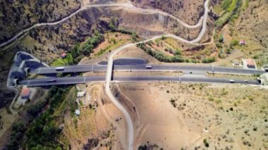 Dağlardan geçen iki şeritli bir otoyolun havadan görüntüsü. Dağ yolu. Köprüleri ve tünelleri olan dağ bölümü, Aerial View. Hindi.Yüksek kalite 4K görüntü