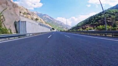 Siyah asfalt ve taze beyaz işaretlerle dağ yolunda sür. Arabayla seyahat, birinci şahıs manzaralı. POV ulaşım aracı ileri. Yüksek kalite 4k görüntü