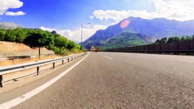 Siyah asfalt ve taze beyaz işaretlerle dağ yolunda sür. Arabayla seyahat, birinci şahıs manzaralı. POV ulaşım aracı ileri. Yüksek kalite 4k görüntü