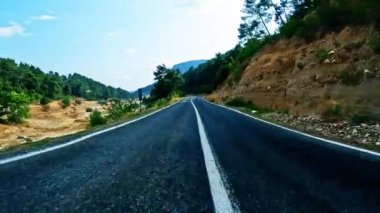 Siyah asfalt ve taze beyaz işaretlerle dağ yolunda sür. Arabayla seyahat, birinci şahıs manzaralı. POV ulaşım aracı ileri. Yüksek kalite 4k görüntü