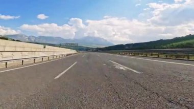 Siyah asfalt ve taze beyaz işaretlerle dağ yolunda sür. Arabayla seyahat, birinci şahıs manzaralı. POV ulaşım aracı ileri. Yüksek kalite 4k görüntü