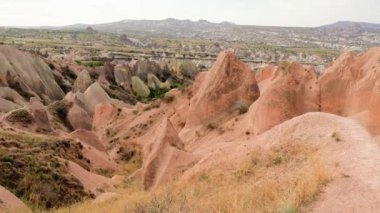 Kapadokya bölgesindeki Kırmızı Gül Vadisi manzarası. Arka planda gökyüzü olan kayalık dağların güzel manzarası. Ünlü turist eğlencesi. Yüksek kalite 4k görüntü
