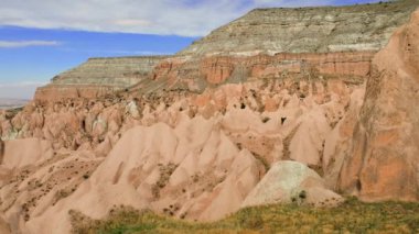 Kapadokya bölgesindeki Kırmızı Gül Vadisi manzarası. Arka planda gökyüzü olan kayalık dağların güzel manzarası. Ünlü turist eğlencesi. Yüksek kalite 4k görüntü