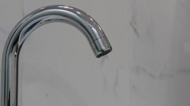 Banyodaki lavabo suyunu kapat paslanmaz çelik musluk ya da vadi su damlası, tuvaletteki ağır su krom musluğu, enerji tasarrufu ve çevreyi koruma kavramı..
