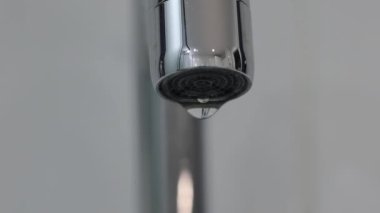 Metal musluk başlığı damlayan su damlacıkları makro şutu kapatır. Gerçek zamanlı, insan yok, yüzeysel alan derinliği. Yüksek kalite 4k görüntü