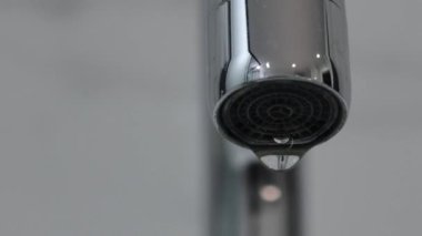 Metal musluk başlığı damlayan su damlacıkları makro şutu kapatır. Gerçek zamanlı, insan yok, yüzeysel alan derinliği. Yüksek kalite 4k görüntü