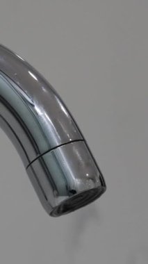 Metal musluk başlığı damlayan su damlacıkları makro şutu kapatır. Gerçek zamanlı, insan yok, yüzeysel alan derinliği. Yüksek kalite 4k görüntü