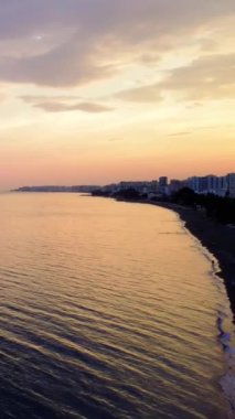  Günbatımında, Türkiye 'nin güneyindeki Mersin Akdeniz kıyı şeridinin çarpıcı hava manzarası şehri, plajları ve sakin denizi göstererek gezginleri cazibesine davet ediyor.