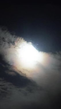 Zaman atlaması, deniz üzerinde yükselen dolunayı yakalar, sürüklenen bulutlar tarafından çerçevelenir, kıyı şehrinin arka planına karşı, büyüleyici bir gökyüzü manzarası yaratır.