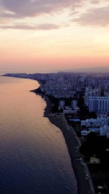 Akdeniz güneşi batarken insansız hava aracı, sakin okyanus dalgalarının kumlu kıyıları kucakladığı Mersin kıyılarını yakalıyor. Hava manzarası çarpıcı bir Akdeniz manzarası çiziyor. Türkiye.