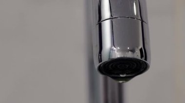 4 bin. Musluktan lavaboya damlayan su. Yakın plan. Boru temizleme tezgahından akan makro su. Tesisat ve ev yenileme konsepti. Yüksek kalite 4k görüntü