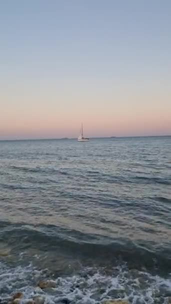 サンセットヨットの静けさ 日没にトロピカル海で巡航する帆船 静かな美しさを捉えます サンセットヨットの豪華さ 帆船の魅力を紹介するのに最適です ユニークなサンセットヨット 帆船ビジュアル — ストック動画