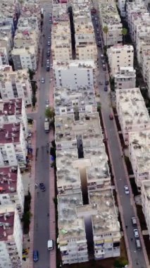 Mersin üzerindeki insansız hava aracı görüntüsü günbatımında evlerin çatılarını ortaya çıkararak kentsel manzarayı gözler önüne seriyor. Hava görüntüleri evlerin çatılarını, hindilerin yeniliklerini ön plana çıkarıyor. Teknoloji teması için mükemmel, evlerin çatılarını gösteriyor.