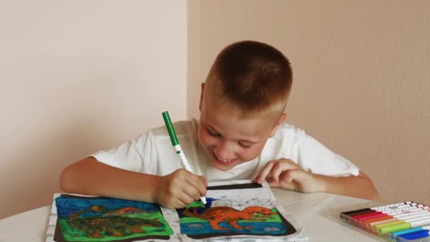 8岁的小学生在家里 用毛笔把书涂成彩色 儿童填装着色书时 在家学习的亮点 每次中风都显示出男孩子们对学习和配色的热衷 — 图库视频影像