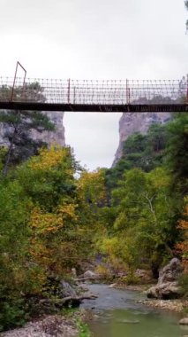 İHA, Türkiye 'nin Kapikaya Kanyonu' nda asma köprü altında uçuyor. Yürüyüş ve yürüyüş meraklıları için ideal. Askıya alınan köprü, sağlıklı bir yaşam tarzını teşvik ederek, yürüyüş macerasını sembolize eder..
