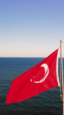 Denizde kızıl Türk bayrağı, Türk kültürünün canlı bir sembolü. Ulusal bayrak dalgaları, Türk kültürünü ve mirasını özetliyor. Her dalga Türk kültürünü ve ulusal bayrağını yansıtıyor.