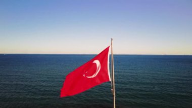 Denizde kızıl Türk bayrağı, Türk kültürünün canlı bir sembolü. Ulusal bayrak dalgaları, Türk kültürünü ve mirasını özetliyor. Her dalga Türk kültürünü ve ulusal bayrağını yansıtıyor.