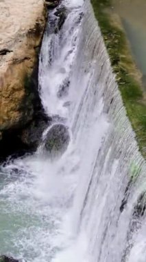 Nehir suyu yapay barajın içinden güçlü bir şekilde akar, insan yapımı bir mucize. Suni baraj nehir akışını kontrol ediyor. Su, yapay baraj yoluyla akar, doğa ve mühendisliğin bir karışımıdır.