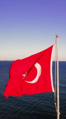 Deniz dalgalarında Türk bayrağı, özgürlüğün sembolü, demokrasi. Rüzgarda dans eden kırmızı bayraklar özgürlüğü ve demokrasiyi temsil eder. Özgürce dalgalanan Türk bayrağı, ulusal özgürlük ve demokrasi anlamına geliyor
