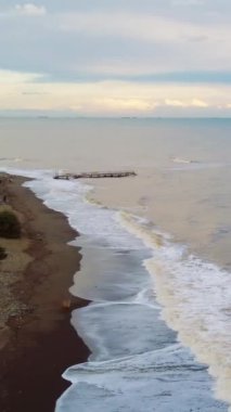 Drone, panoramik plaj manzarasını gün batımında, Akdeniz cazibesini yakalar. Panoramik plaj manzarası, şehrin ufuk çizgisi arkaplanı. Gün batımında plajlar panoramik bir ihtişam, seyahat ve eğlence cenneti.