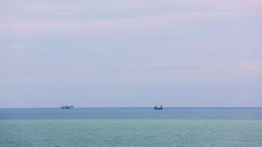 Türkiye 'nin Mersin kentinde demirli gemiler, Akdeniz' de günbatımında. Kargo konteynır gemisi kıyıya yanaştı, limanı bekliyor. Endüstriyel gemi alacakaranlıkta Türk limanında demirledi.