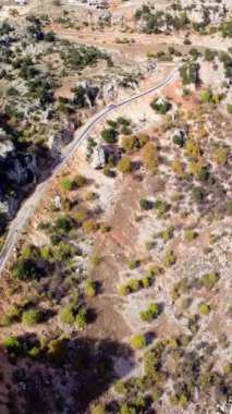 İnsansız hava aracı dağ vadisinde yol üzerinde süzülürken yakalanır. Kayaların yanındaki hava yolculuğu manzarası macera arayanlar için mükemmel. Engebeli arazinin insansız hava aracı görüntüleriyle gezmeyi kucaklayın..
